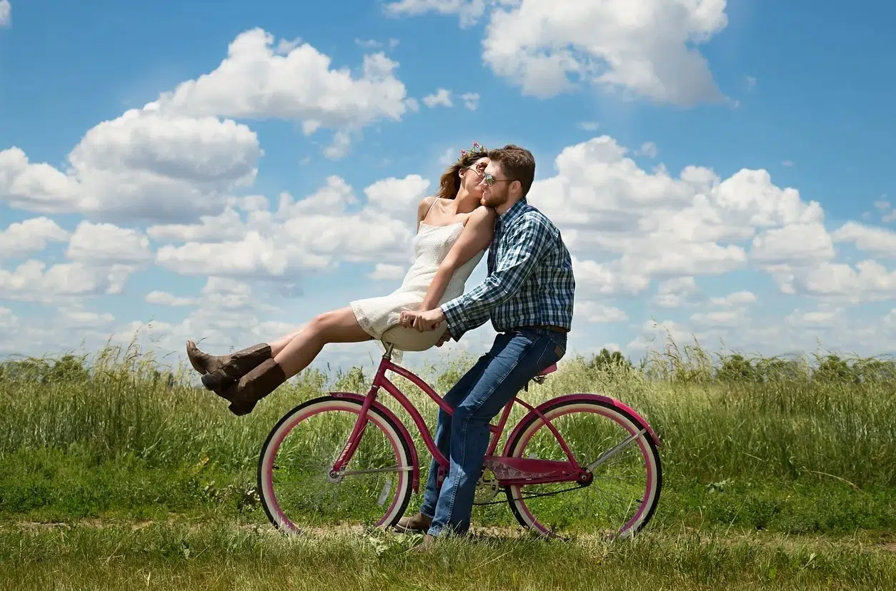 Couple sur un vélo dans un champ