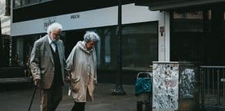 man in black suit standing beside woman in white coat