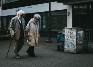 man in black suit standing beside woman in white coat