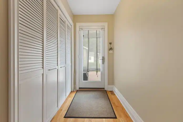 a hallway with a door and a rug on the floor