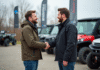 Les astuces pour réduire le prix d’achat de votre quad homologué Homme souriant serrant la main d'un conseiller avec un quad neuf