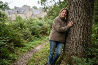 Femme touchant un chêne dans la forêt près de Liffré